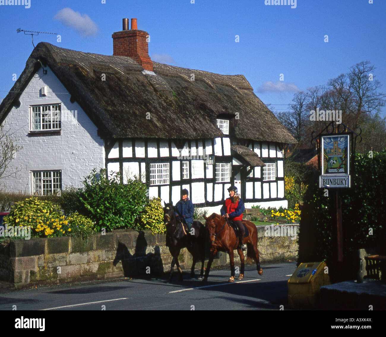 Reiter, die vorbei Bunbury Cottage im Frühjahr, Bunbury, Cheshire, England, UK Stockfoto