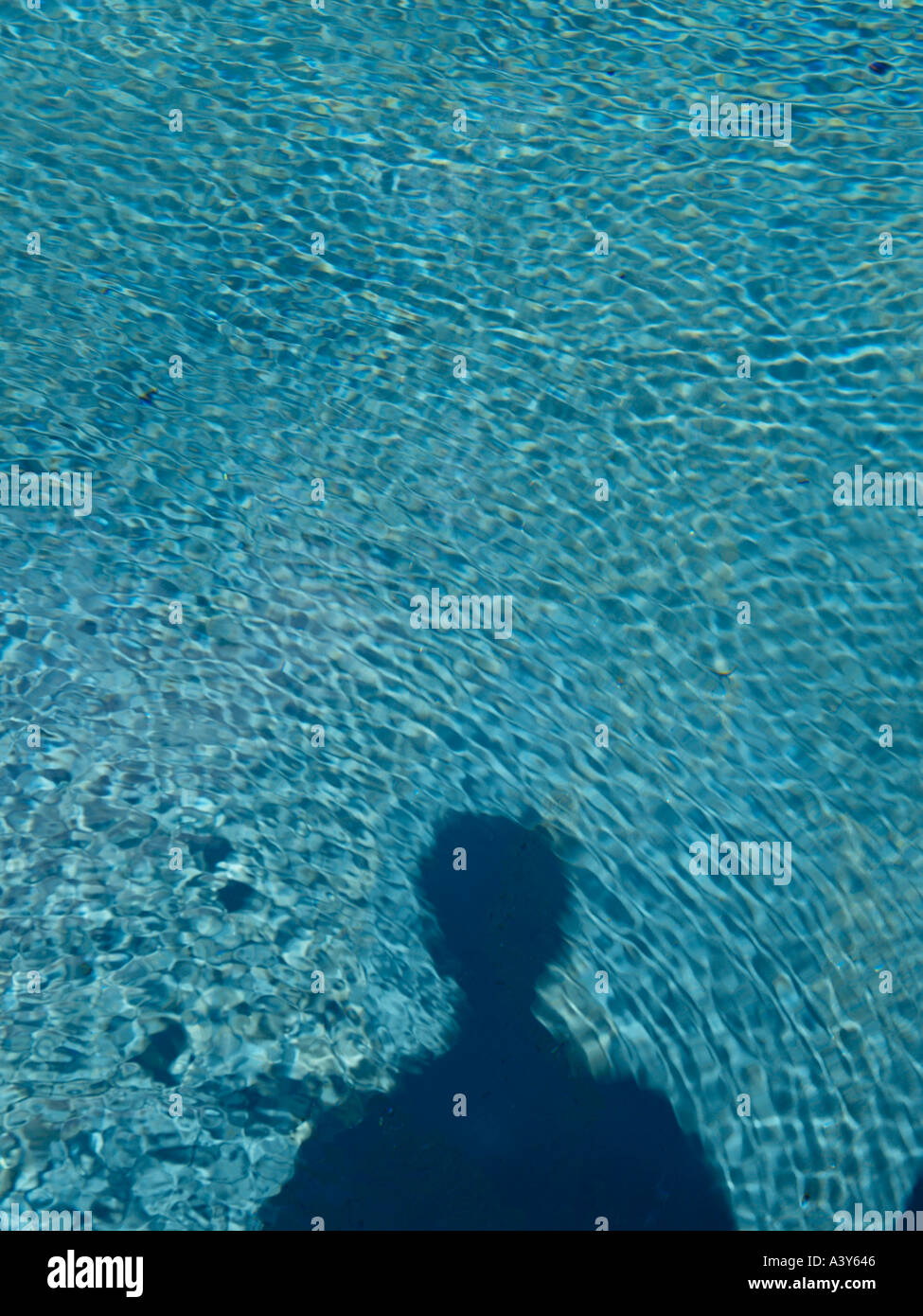 vertikal mit dem Schatten eines Mannes in einem geriffelten Pool erschossen Stockfoto
