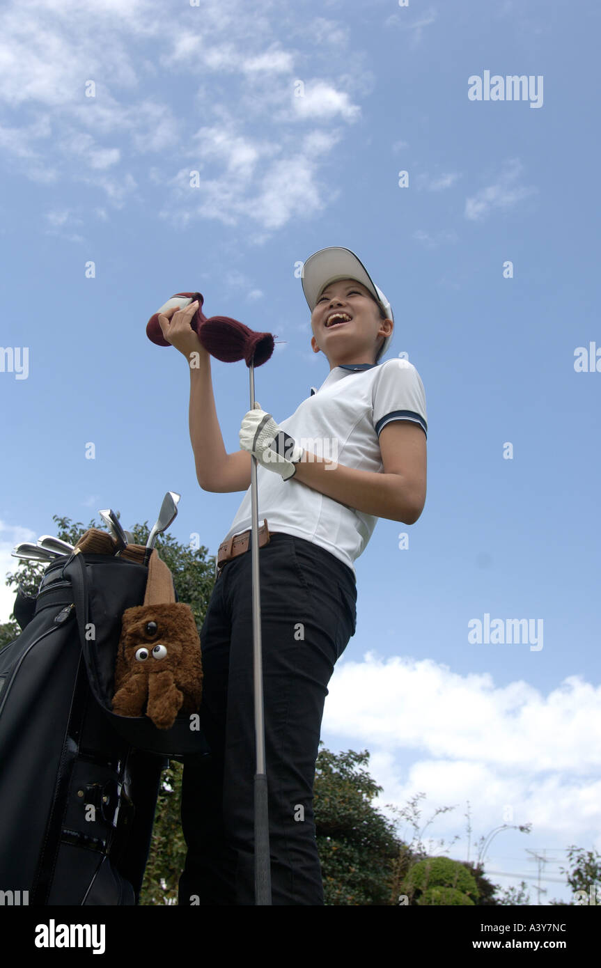 Niedrigen Winkel Ansicht einer Frau entfernen die Kopfbedeckung eines Golfclubs Stockfoto