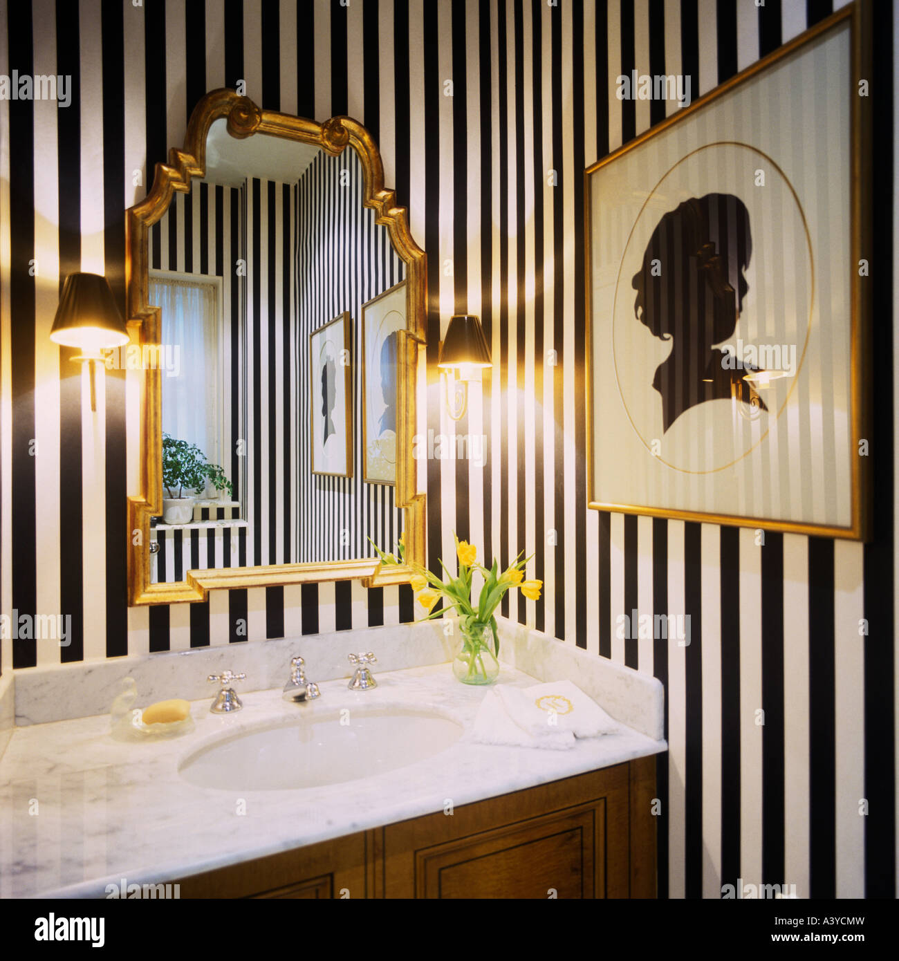 Garderobe mit schwarzen & weiß gestreiften Tapeten und gerahmten Spiegel vergoldet Stockfoto