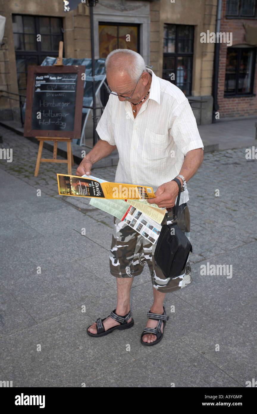 Ein reifer Mann ist eine Karte auf einen Spaziergang durch eine Stadt studieren. Stockfoto