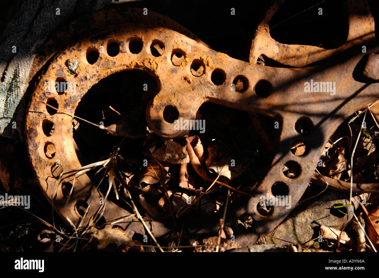 Rostige Metall Landmaschinen liegen Tote Gras und Blätter mit Tuch auf der einen Seite Stockfoto