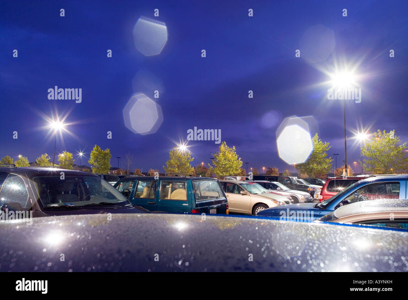 Supermarkt-Parkplatz, Parkplatz in der Regen in der Nacht. Frühherbst. Virginia USA. Linseneffekt verursacht durch Regentropfen auf der Linse. Stockfoto