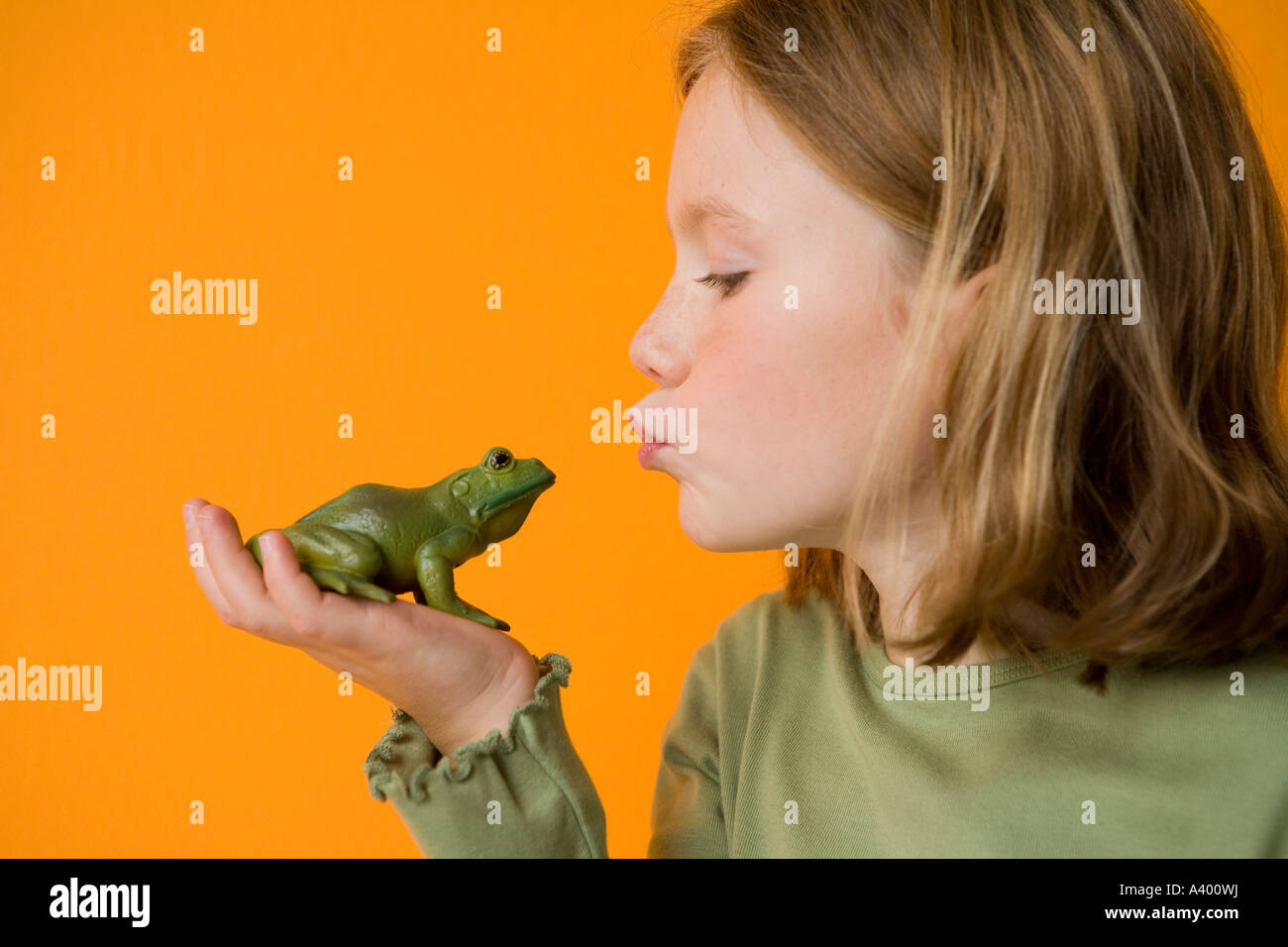 blonde Mädchen Spielzeug Frosch küssen, make a wish Stockfoto