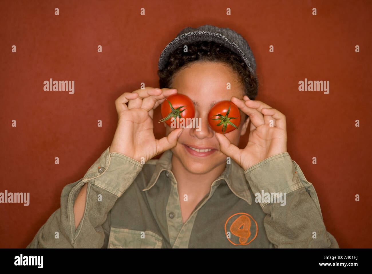 Porträt des jungen für seine Augen mit Tomaten Stockfoto