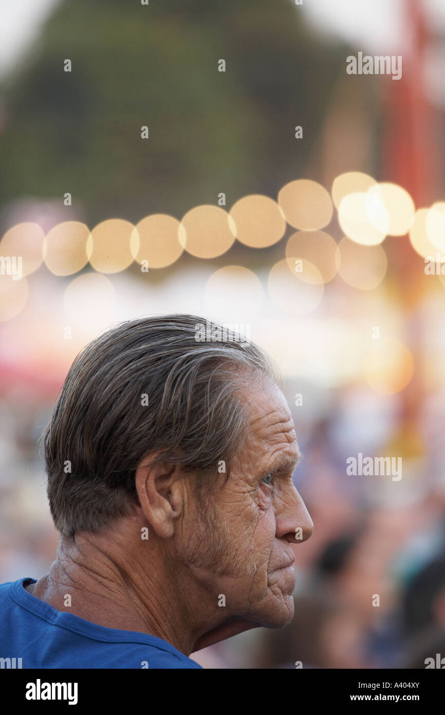 Profil eines alten Mannes an eine kleine Kirmes Stockfoto