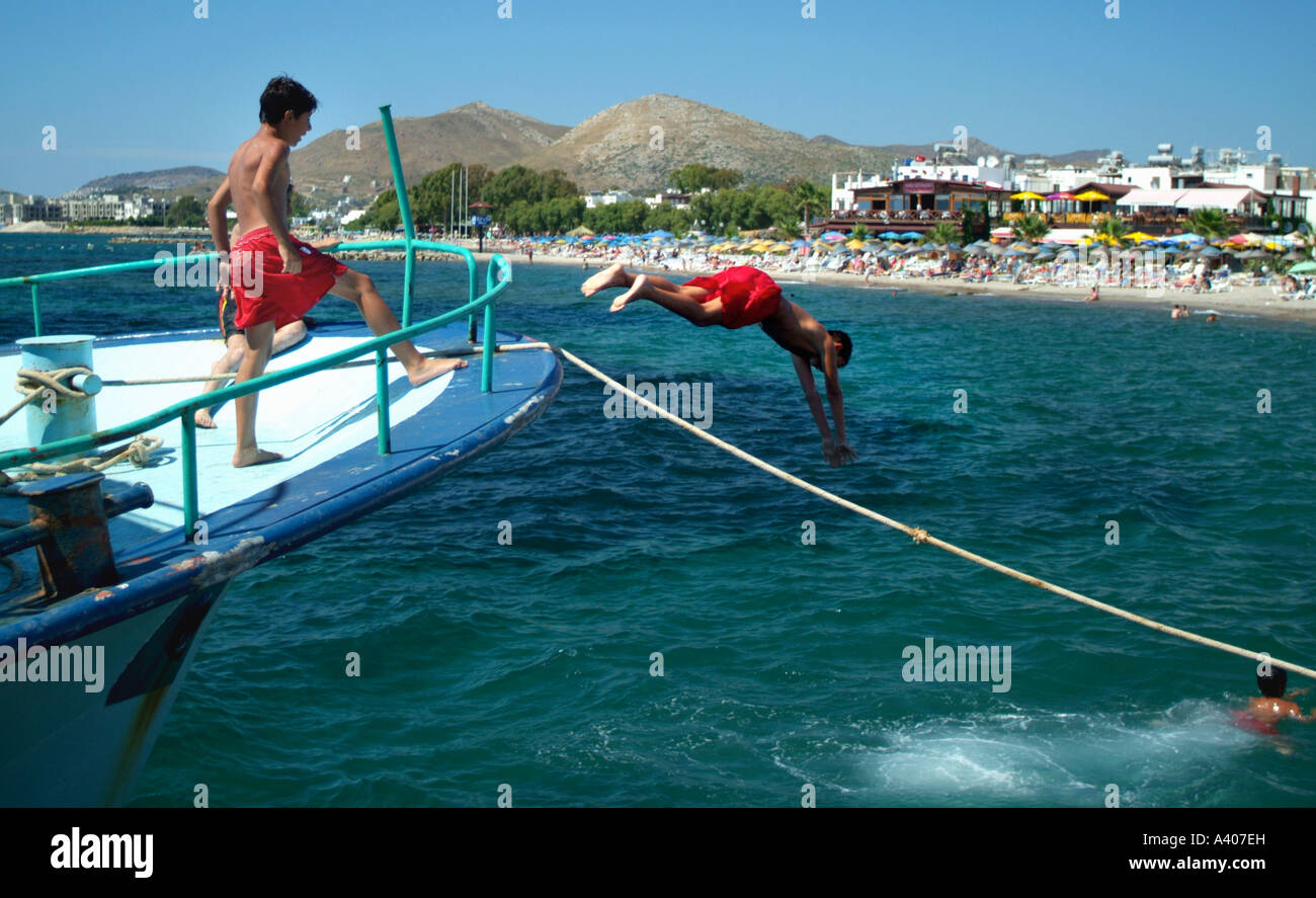 Jungen Tauchen vom Boot in Turgutreis Hafen Türkei Stockfoto
