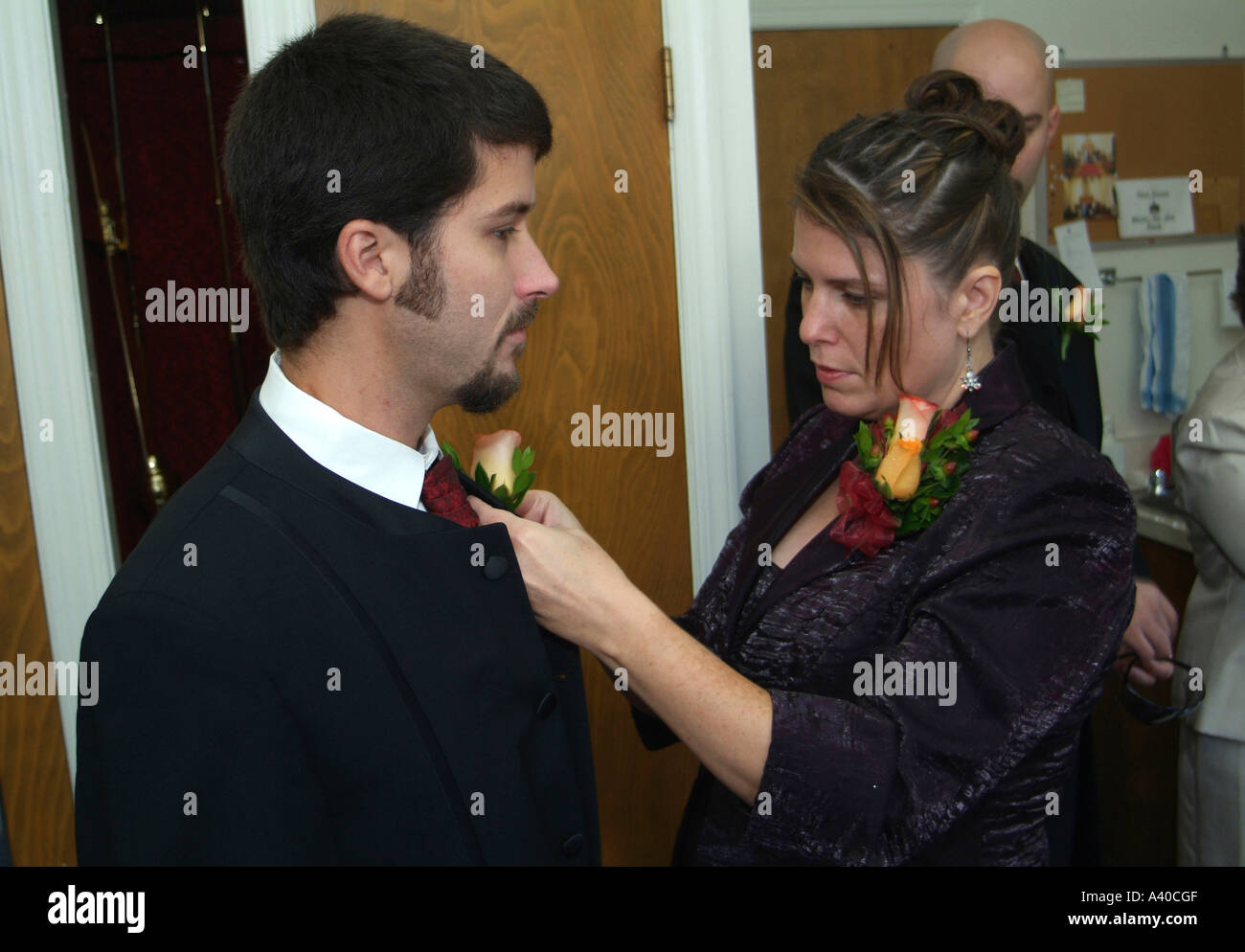 Frau pinning Corsage auf Trauzeuge bei einer Hochzeit Stockfoto