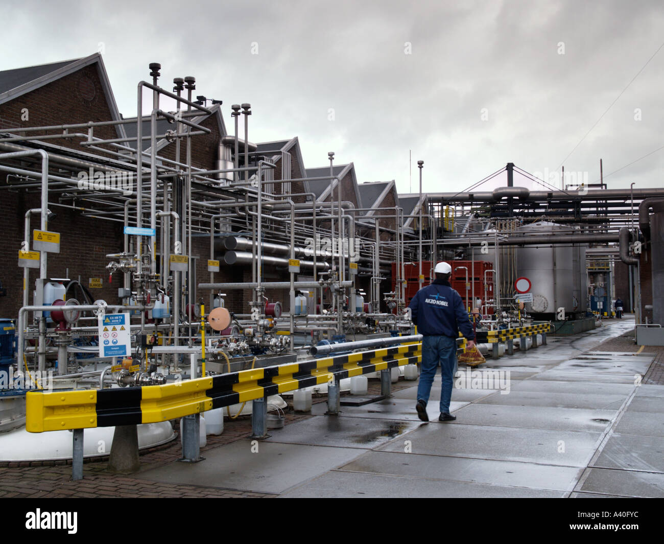 Arbeiter mit Akzo Nobel Jacke entlang chemischen Industrieanlage in Oss, Niederlande Stockfoto
