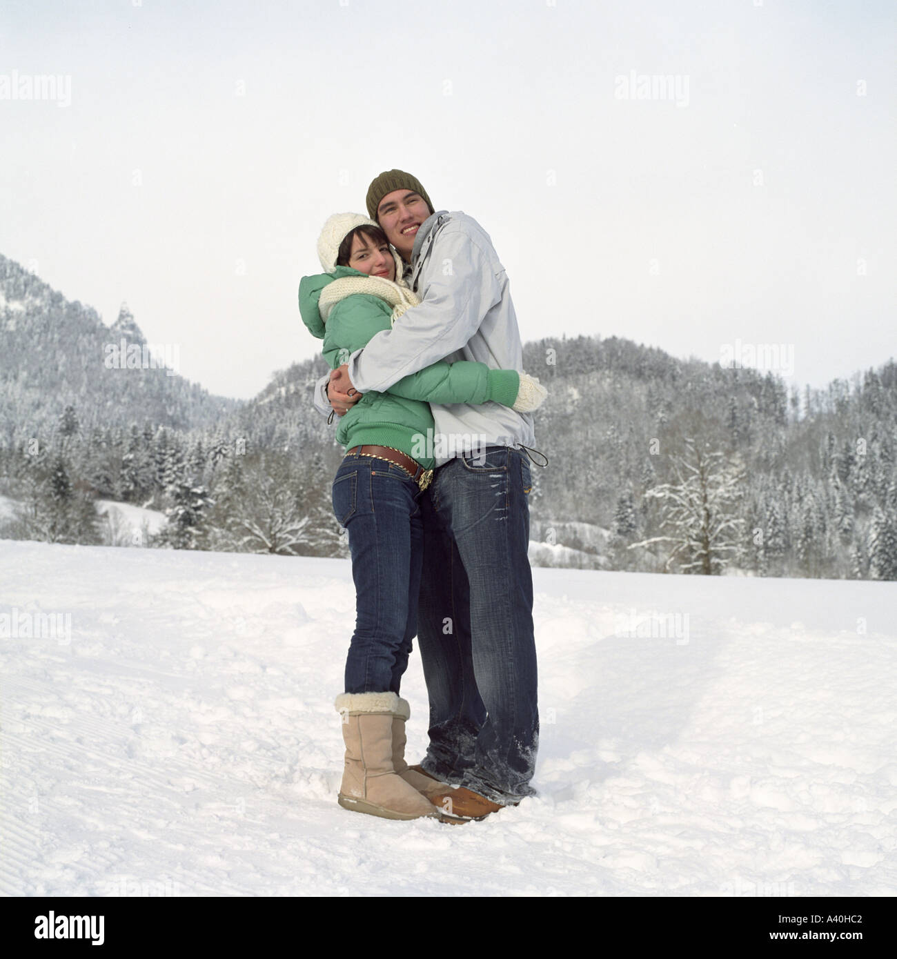 Teenager-paar umarmt einander im Schnee Stockfoto