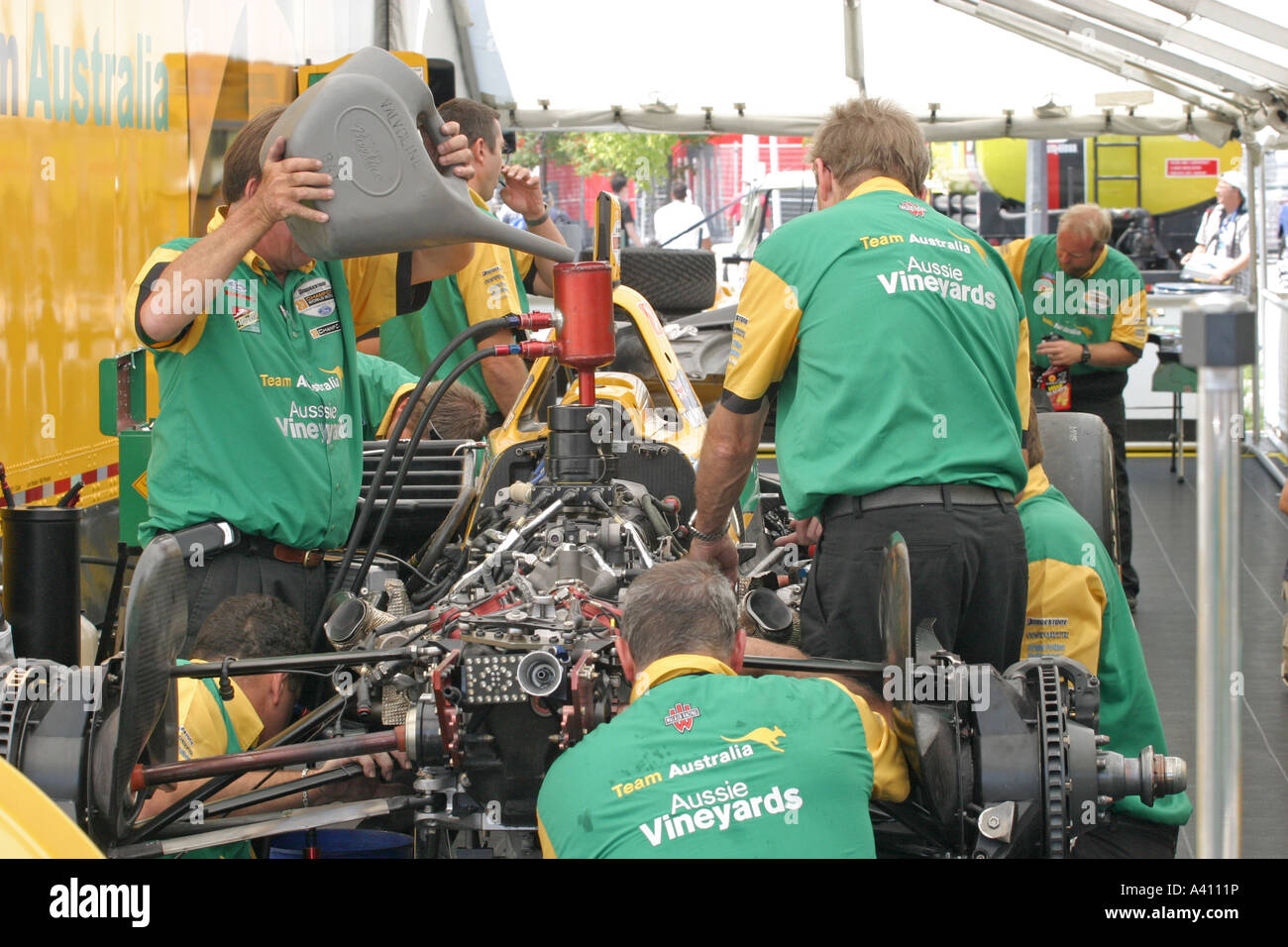 Mechanikerteam arbeitet an Rennwagen im Garagenbereich Stockfoto