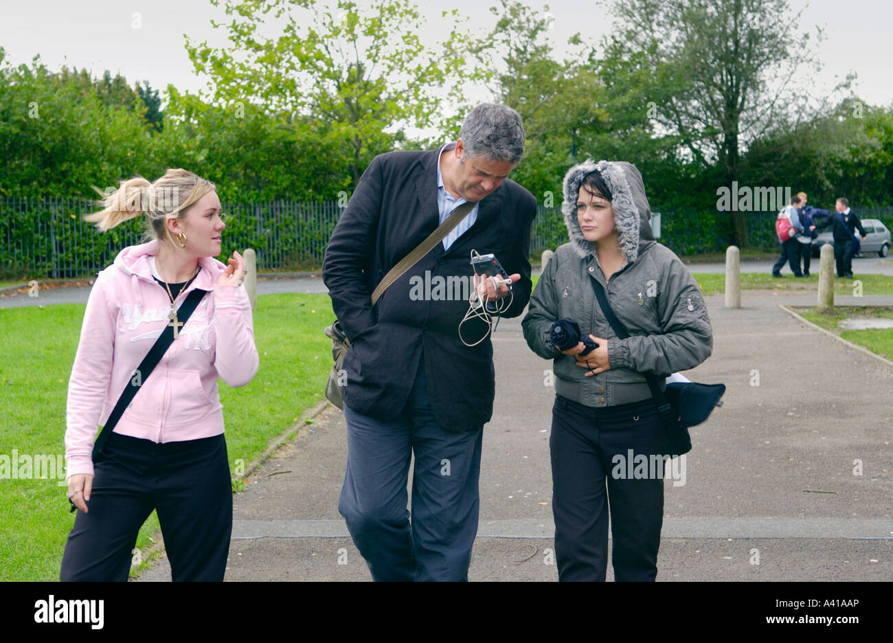 Männliche Journalist interviewt Teenager Schulmädchen in UK-Schule Stockfoto