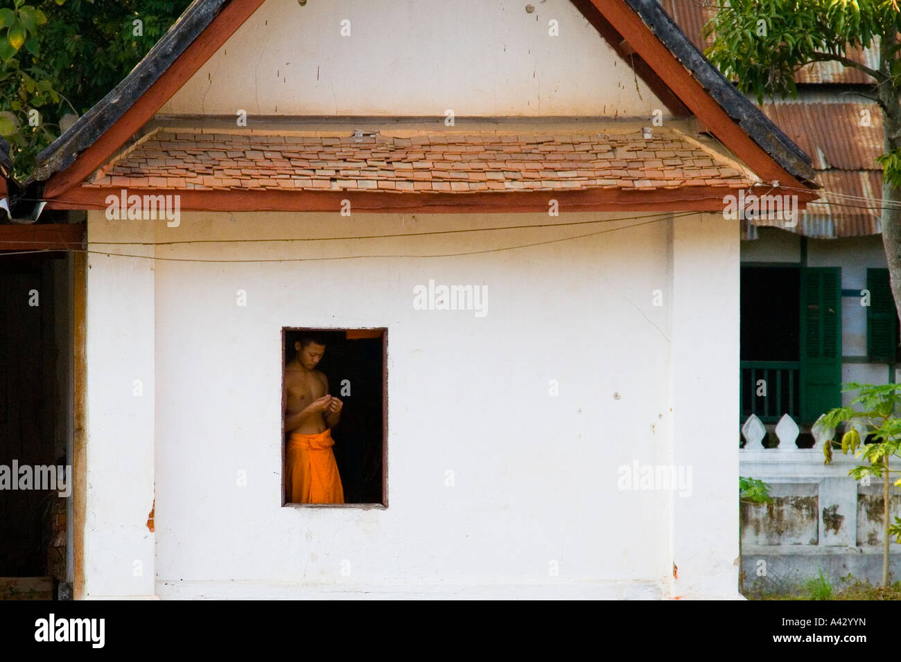 Mönch in einem Fenster Wat Mai Suwannaphumaham Luang Prabang Laos Stockfoto