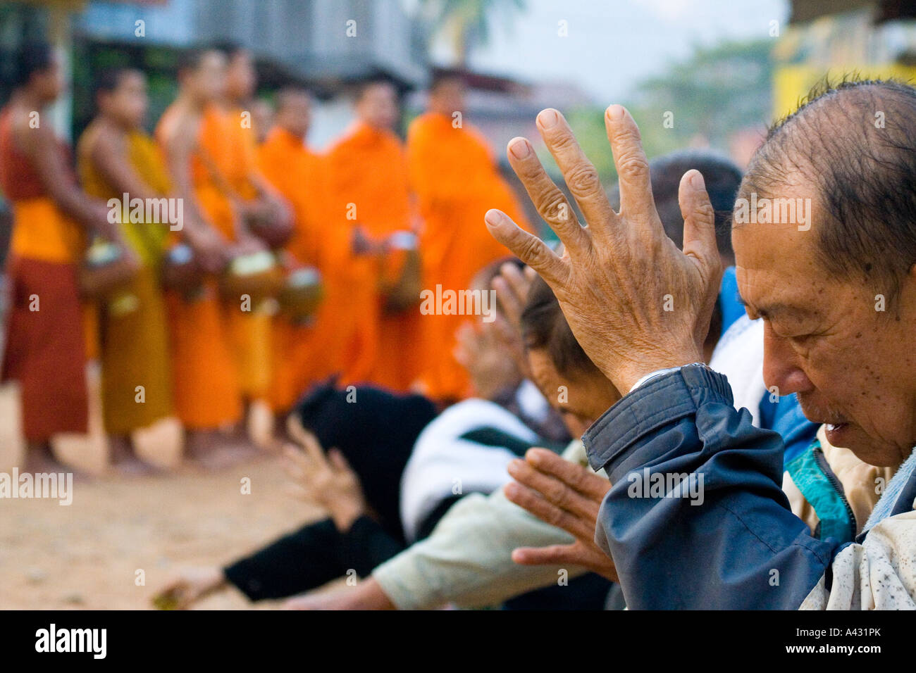 Lokale Leute beten nach dem geben von Almosen Vang Vieng Laos Stockfoto