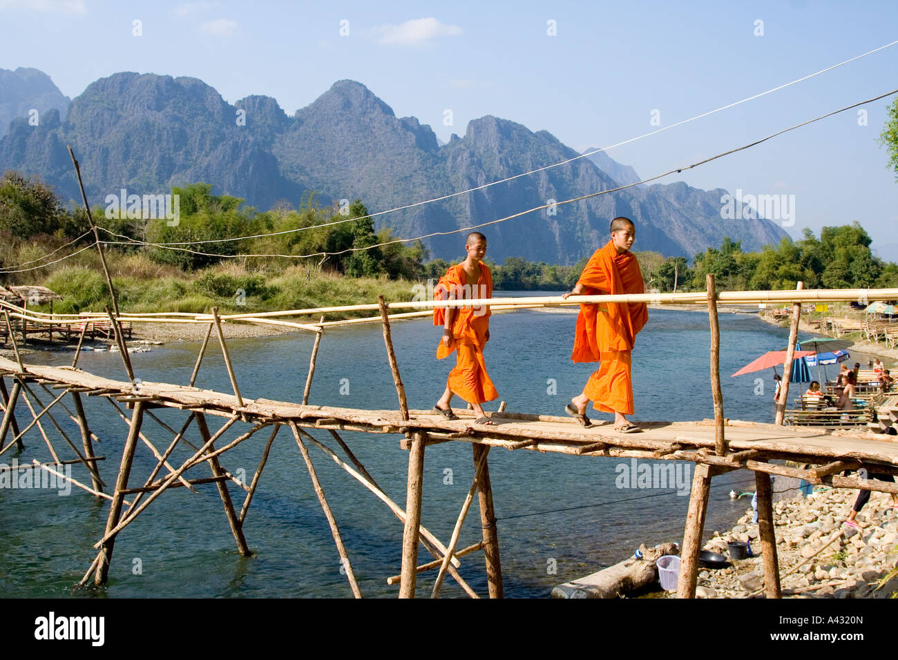 Mönch und Anfänger ein Bambus Brücke Song Fluss Vang Vieng Laos überqueren Stockfoto