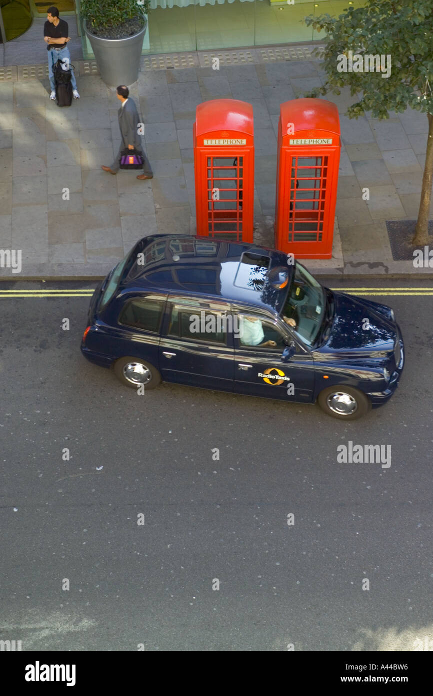 Blick hinunter auf die Straße mit schwarzen Taxis und rote Telefonzellen Stockfoto