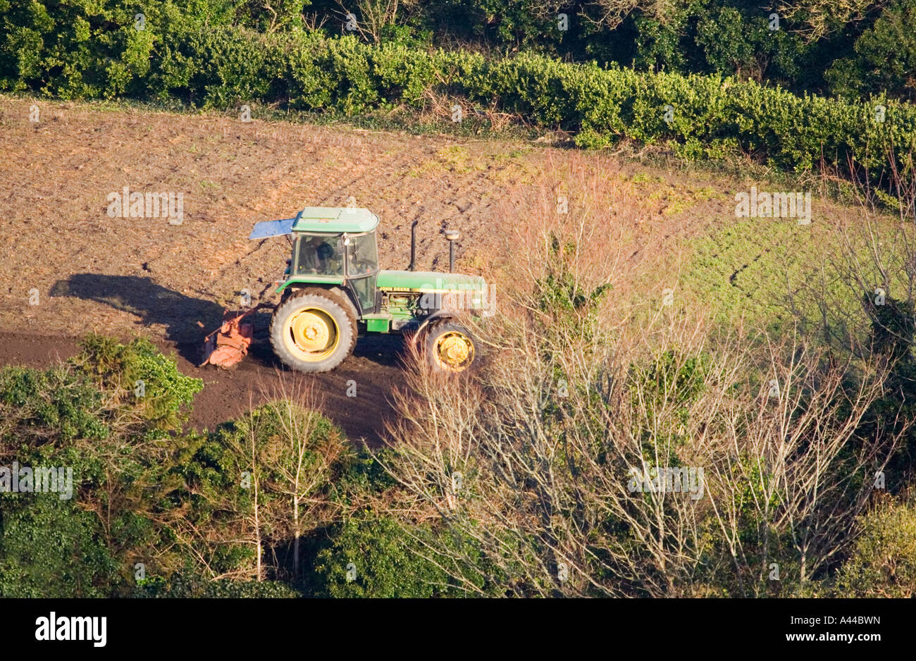 Luftaufnahme von "John Deere" Traktor 3050 Vorbereitung der Flächen zum Bohren von Samen. Am frühen Morgen. North Cornwall. VEREINIGTES KÖNIGREICH. Februar. Stockfoto