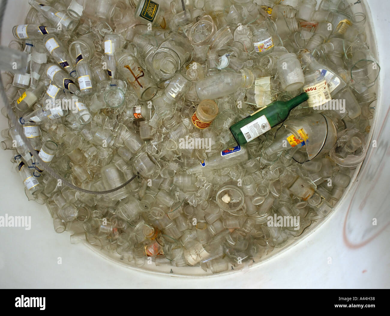 Blick in ein klares Glas Recyclingbehälter, eine seltsame grüne Flasche verdirbt die Sammlung Stockfoto