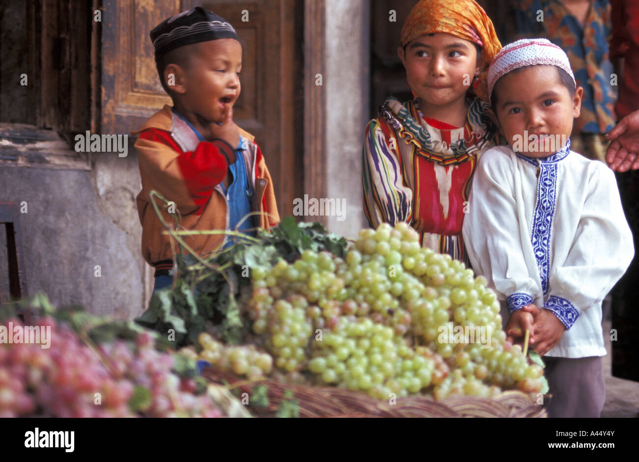 Uyger Kinder stehen die berühmten Trauben von Turpan, Xinjiang, China Stockfoto