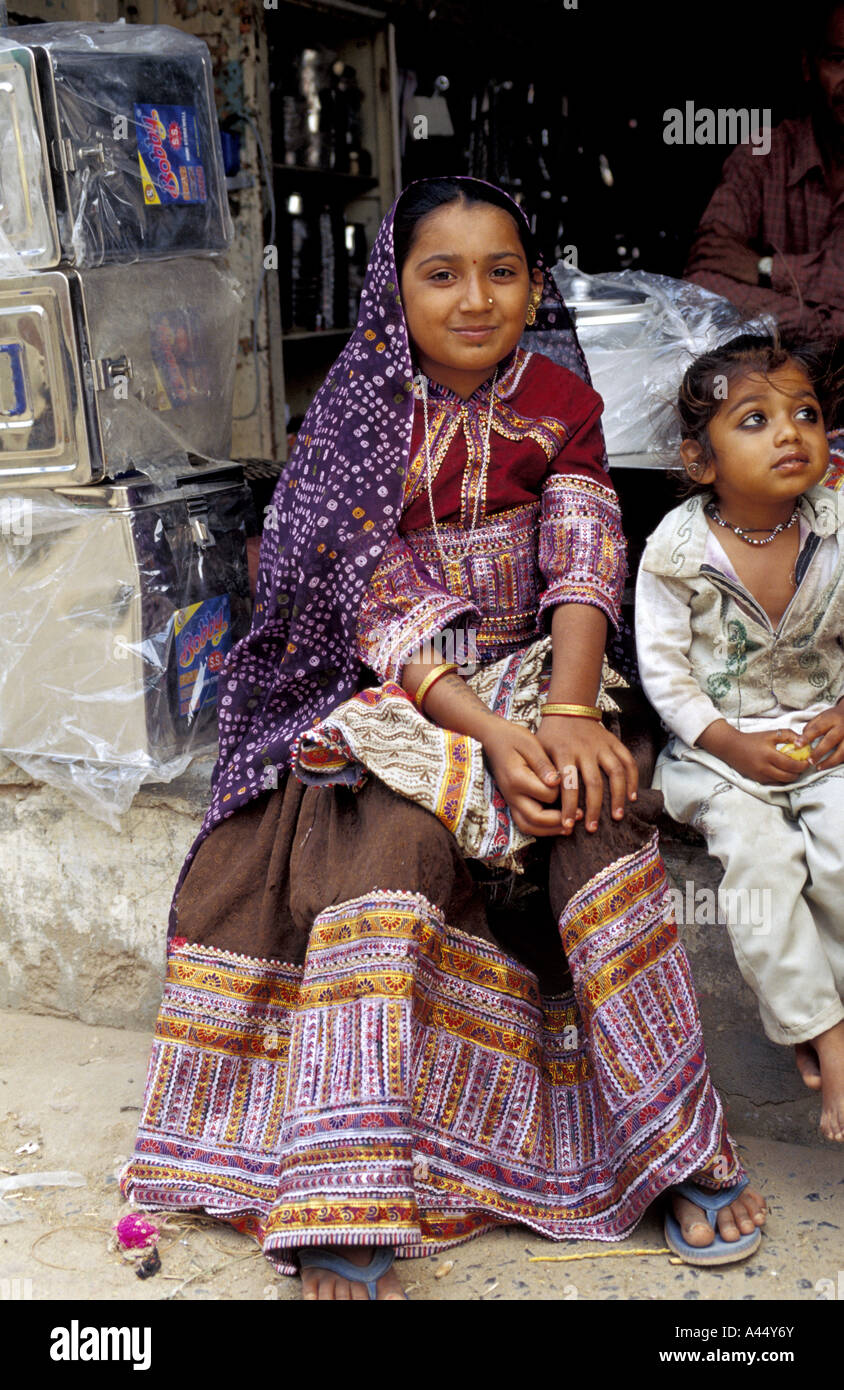 Ein schönes Rabari Mädchen, gekleidet in die Tracht Rabari sitzt in einer Straße in eine kleine Marktstadt in Kutch, Indien Stockfoto