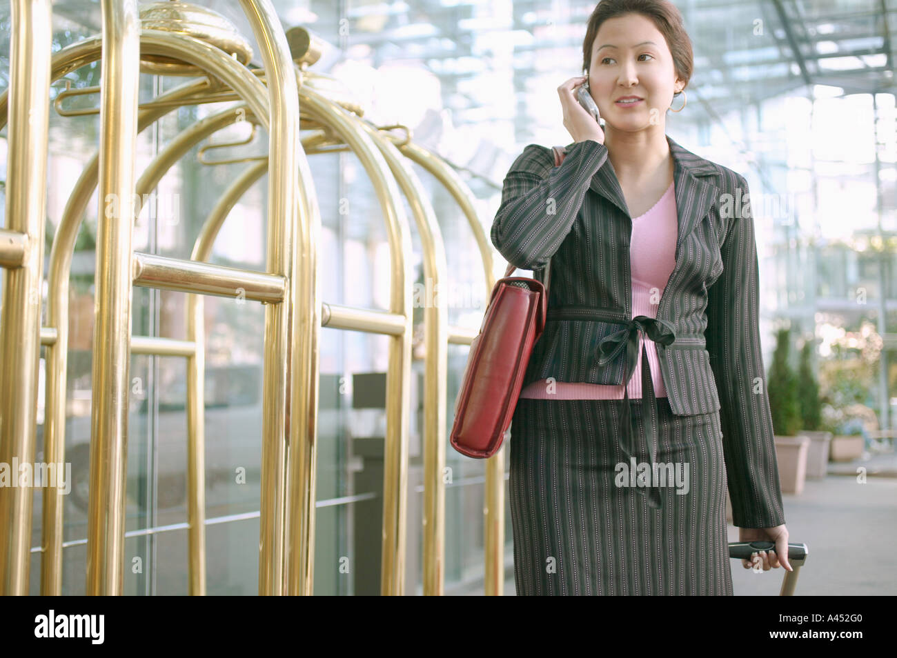 Geschäftsfrau auf Handy in Hotellobby Stockfoto