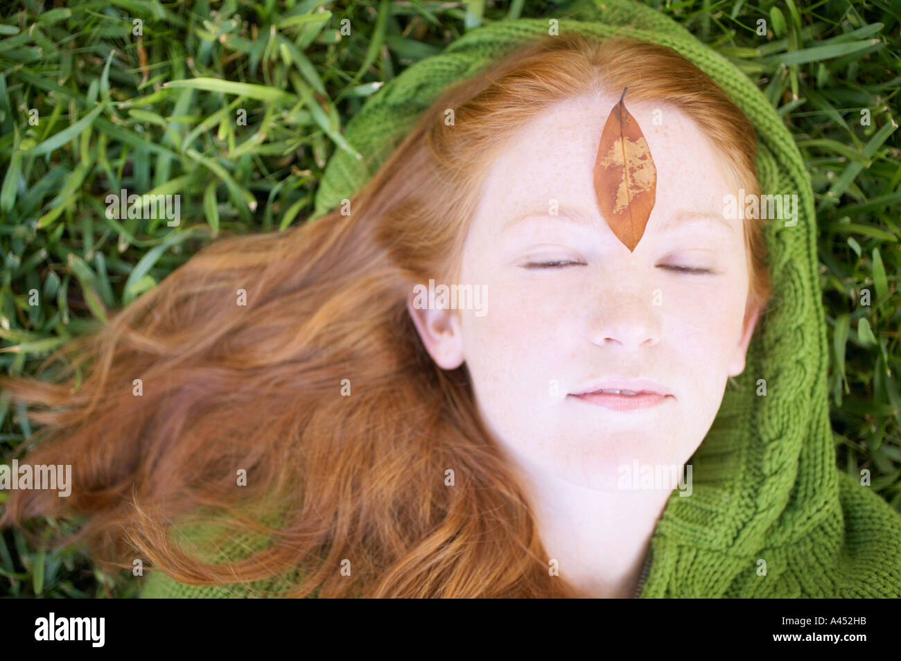 Nahaufnahme der jungen Frau liegt auf dem Rasen Stockfoto