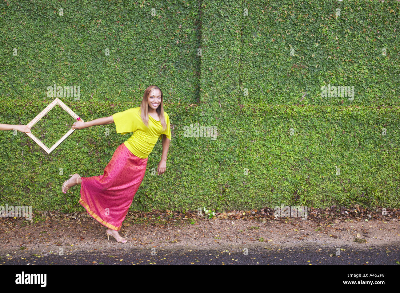 Junge Frau, die einen Rahmen ziehen Stockfoto