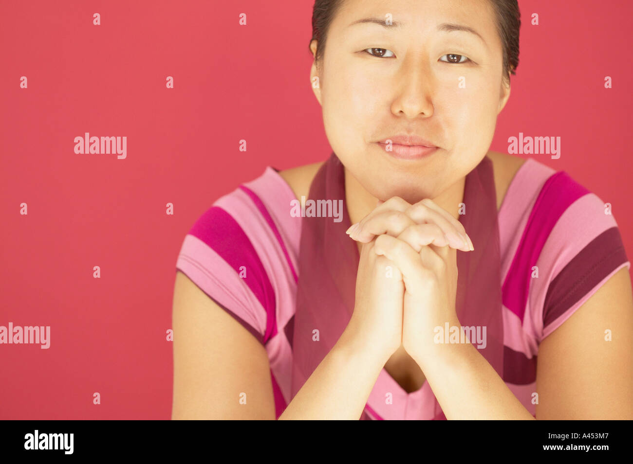 Junge Frau mit Kinn auf ihre Hände ruhen Stockfoto