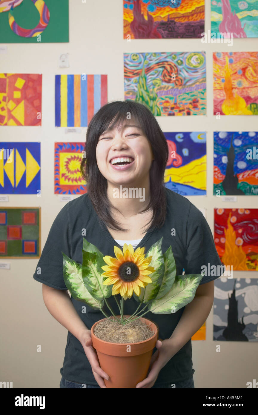 Junge Frau hält eine Topfpflanze Stockfoto