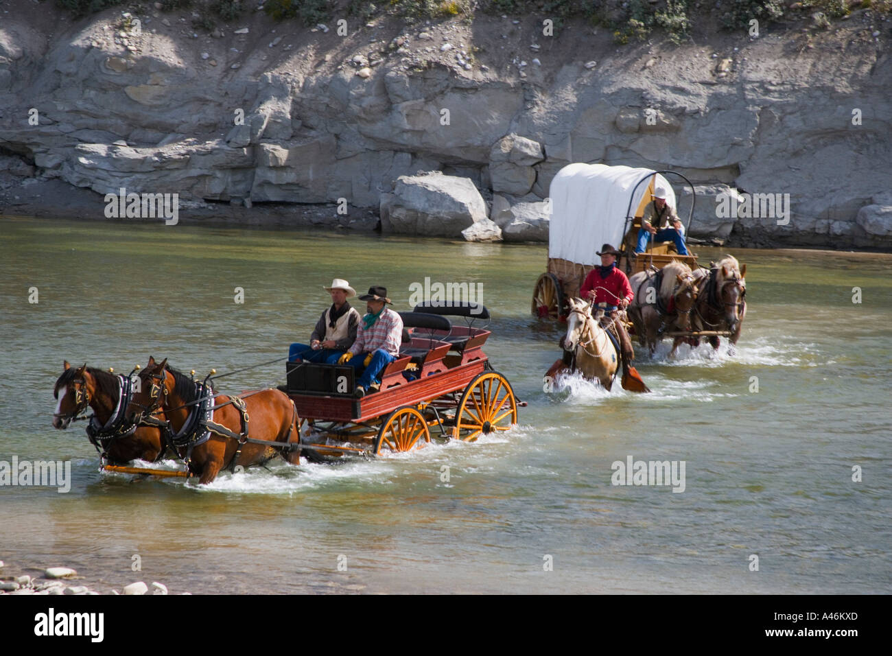 Cowboys und einem Planwagen Überquerung eines Flusses Stockfoto