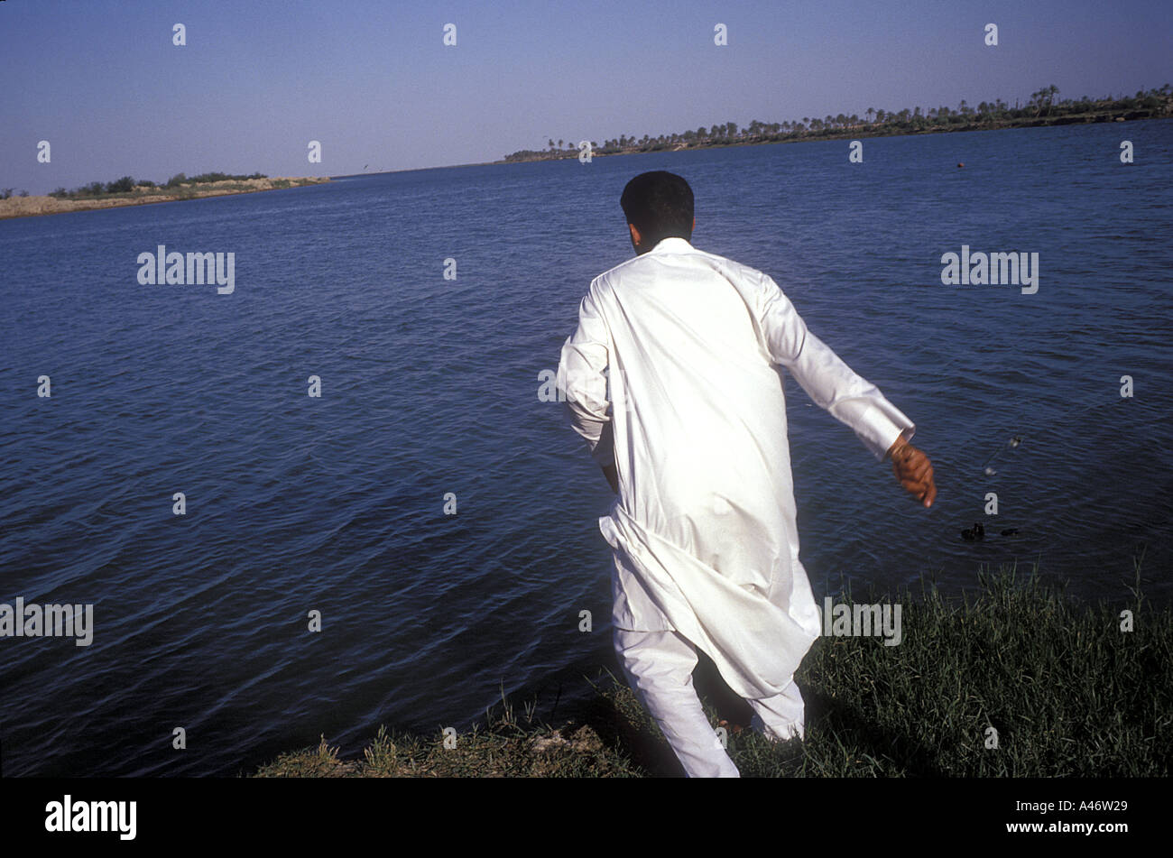 Ein irakischer Mann fischt mit einer Linie am Zusammenfluss zwischen den Flüssen Tigris und Euphrat genannt Al-Qurnah (Qurna) Basra, Irak Stockfoto