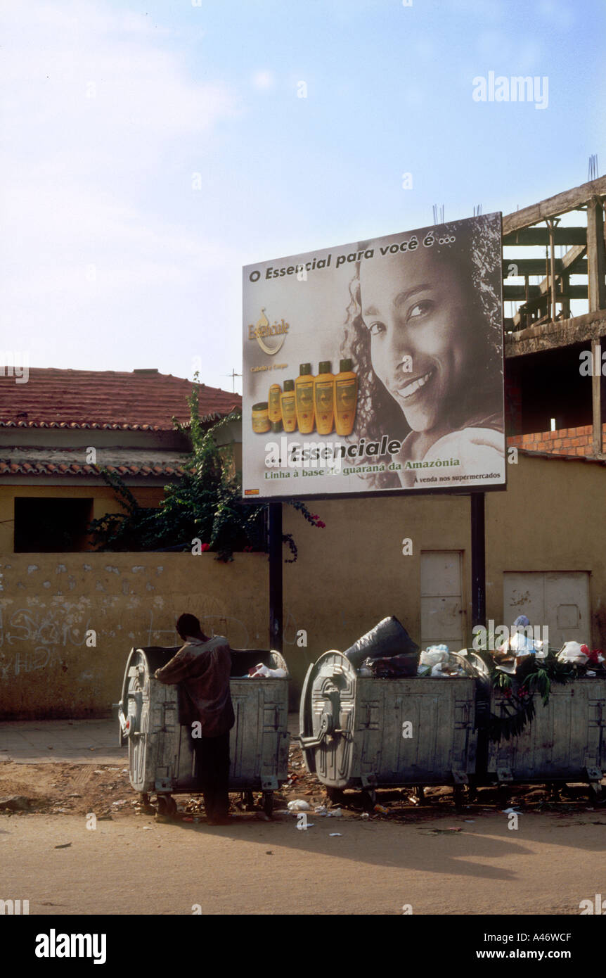 Hungernden Menschen nimmt durch Mülltonnen in Luanda, wie ein Werbeplakat hinter ihm einen wohlhabenden Lebensstil, Angola zeigt Stockfoto