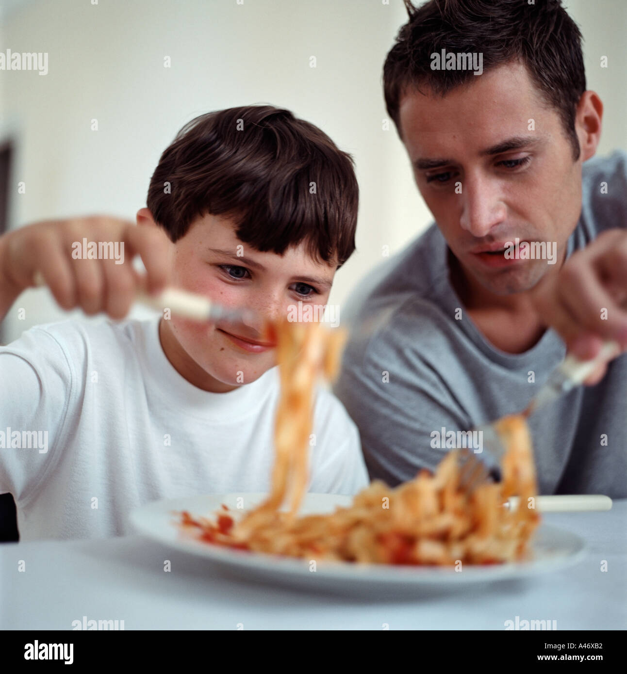 Vater und Sohn Spaghetti-Essen Stockfoto