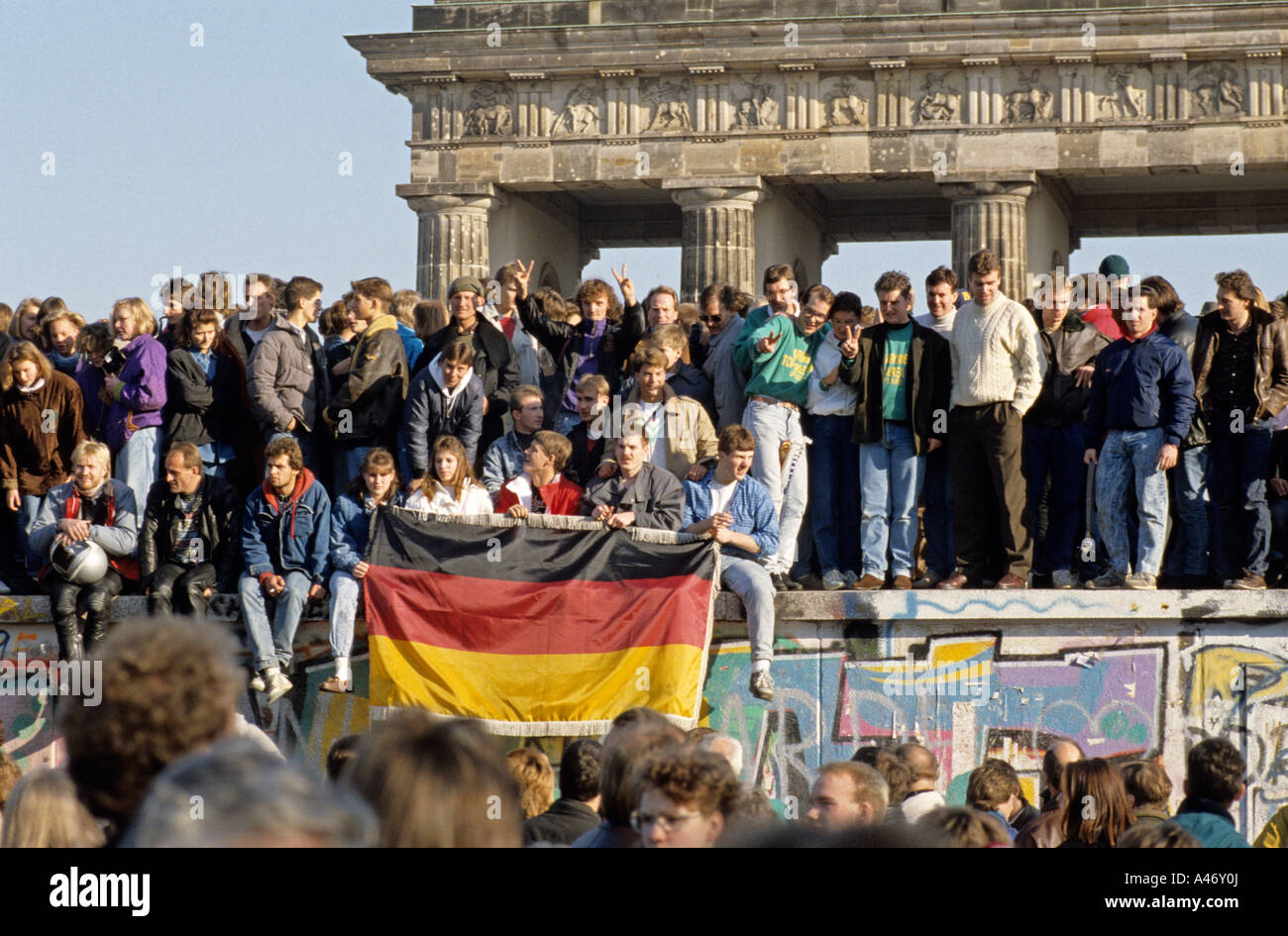 Fall der Berliner Mauer: Menschen aus Ost und West-Berliner Klettern an der Wand vor dem Brandenburger Tor, Berlin, Deutschland Stockfoto