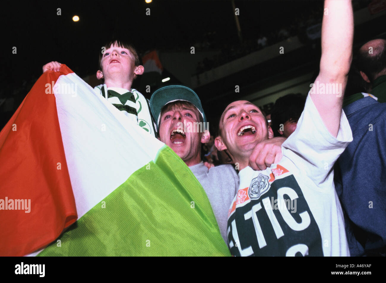 Keltische Fußball-Fans mit einem jungen halten die irische Trikolore unterstützen ihr Team im Celtic Park ground Stockfoto