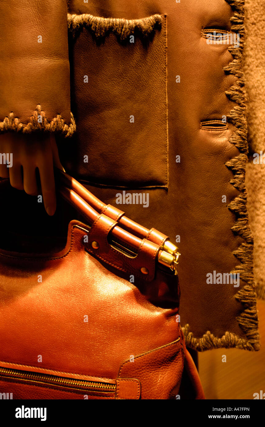 Schaufensterpuppe Shop hält eine orange Leder Geldbörse trägt einen braunen Ledermantel mit einem Embrodered Rand auf Tasche und Hülse Stockfoto