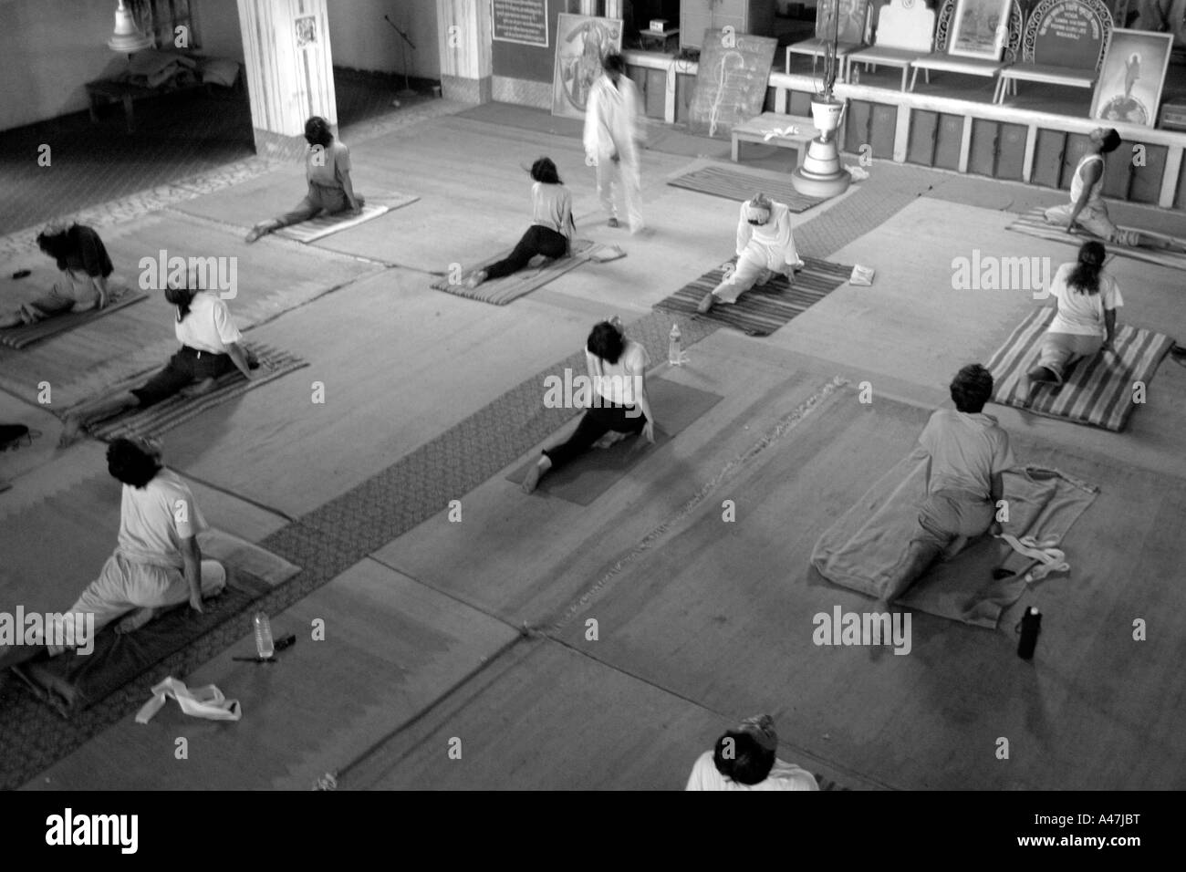 Menschen im Westen praktizieren Yoga-Asanas in einem Ashram in Rishikesh in Indien Stockfoto