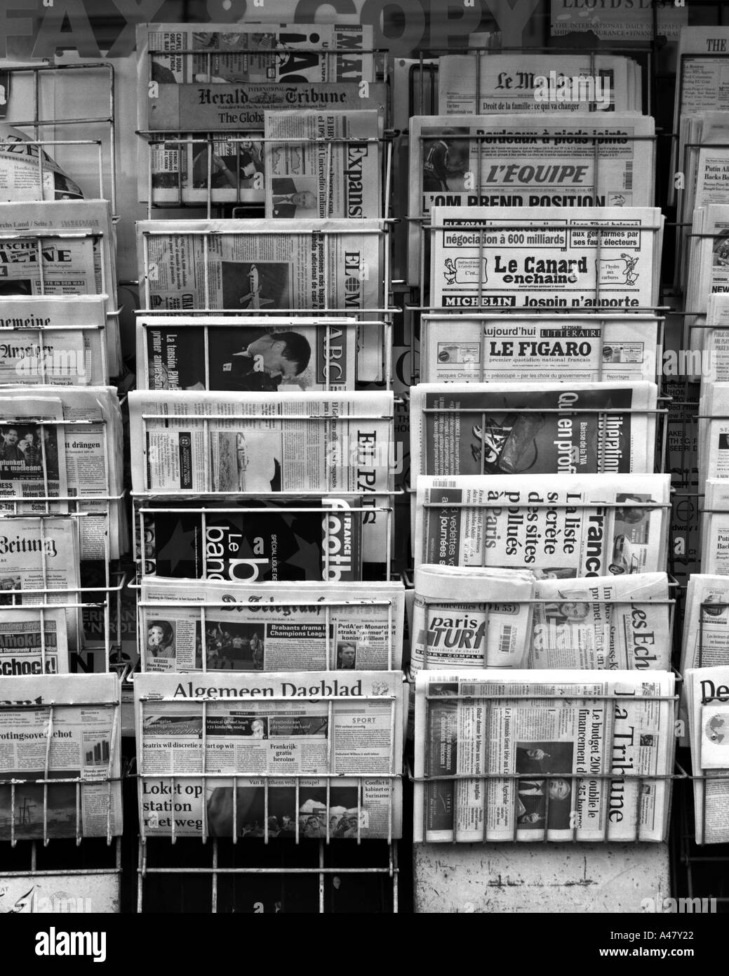 Ein Detail eines städtischen Zeitungsstandes, der ausländische Titel anwirbt und die Forderungen von Besuchern und Touristen in Schwarz und Weiß illustriert Stockfoto