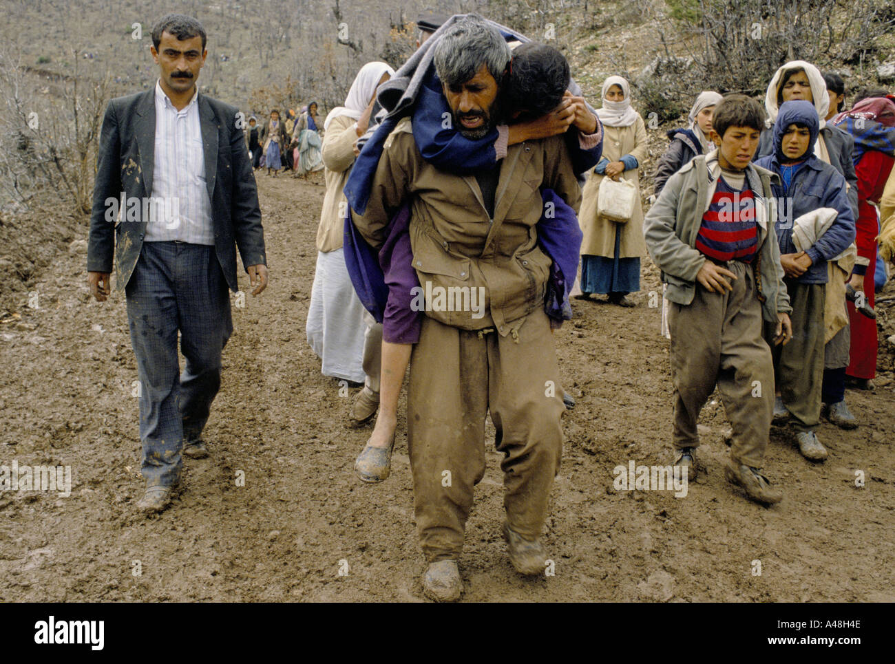 Kurdische Flüchtlinge Irak kommen in der Türkei am Isikveren. Ein Mann trägt seine verletzte Frau Stockfoto