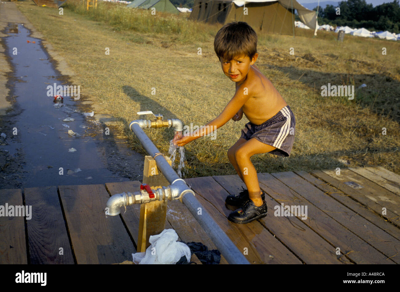 Flüchtlingskind aus Srebrenica im Juli 1995 Tuzla waschen am Standrohr. Tuzla Flughafen Stockfoto