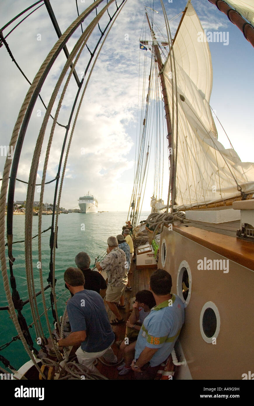 USA-Florida Keys-Crew und Touristen setzen Segel auf Tall Ship mit Kreuzfahrt Schiff und Key Westhafen im Hintergrund Stockfoto