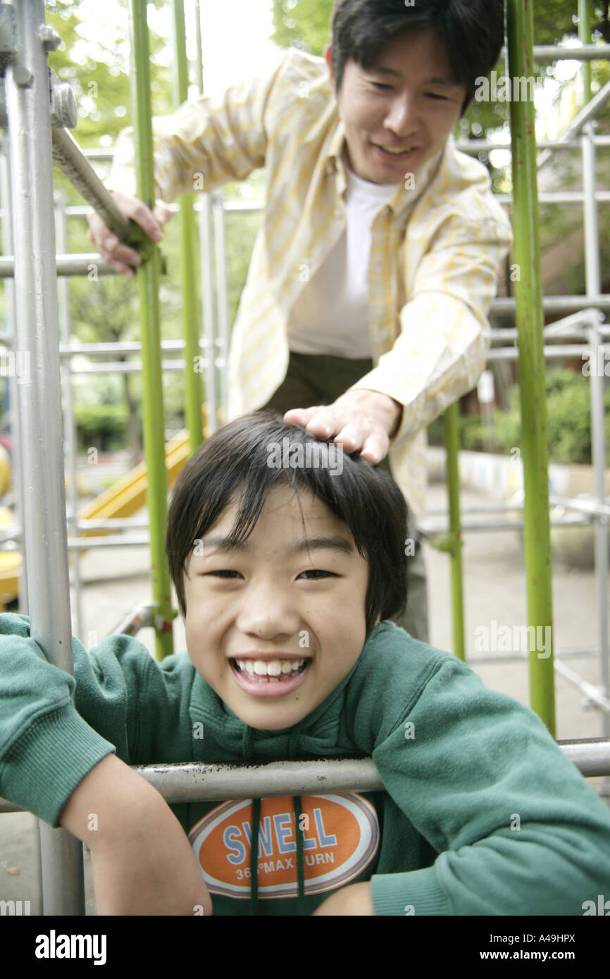 Mitte erwachsener Mann mit seinem Sohn auf einem Klettergerüst spielen Stockfoto