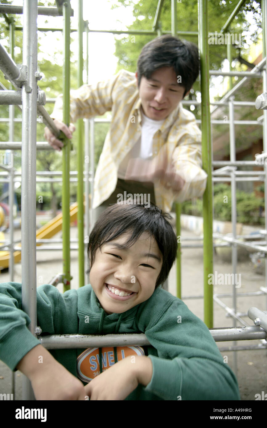 Mitte erwachsener Mann mit seinem Sohn auf einem Klettergerüst spielen Stockfoto