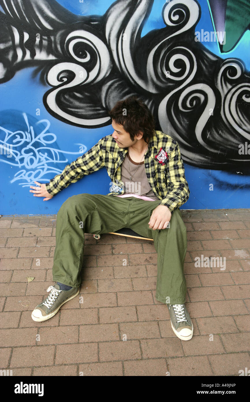 Erhöhte Ansicht eines jungen Mannes sitzt vor einem graffiti Stockfoto