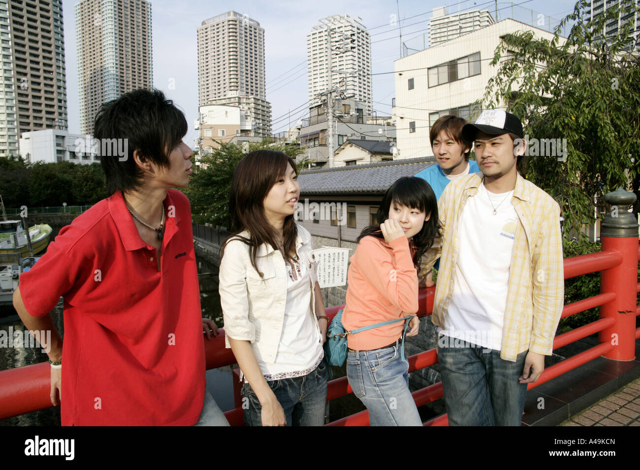 Drei junge Männer und zwei junge Frauen in der Nähe eines Geländers Stockfoto