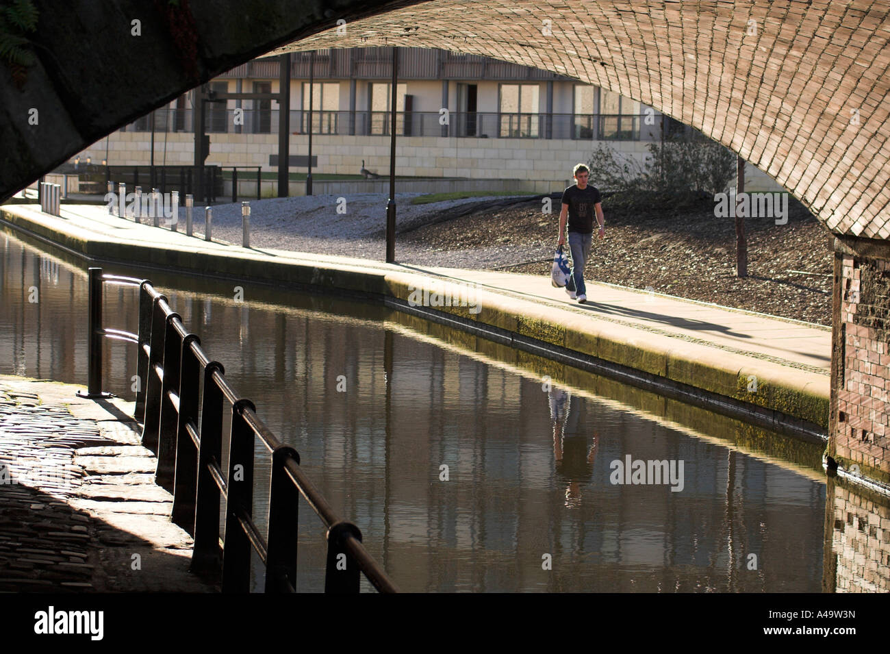 Man Walking am Kanal entlang Pfad, Tarif Street Bridge, Kai, Piccadilly, Manchester, UK Stockfoto