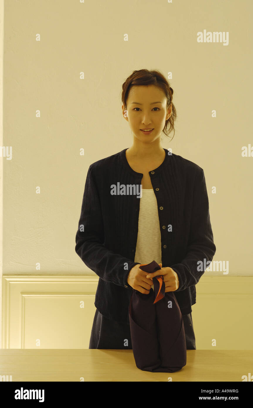 Porträt einer jungen Frau mit zwei Flaschen in ein Tuch gewickelt Stockfoto