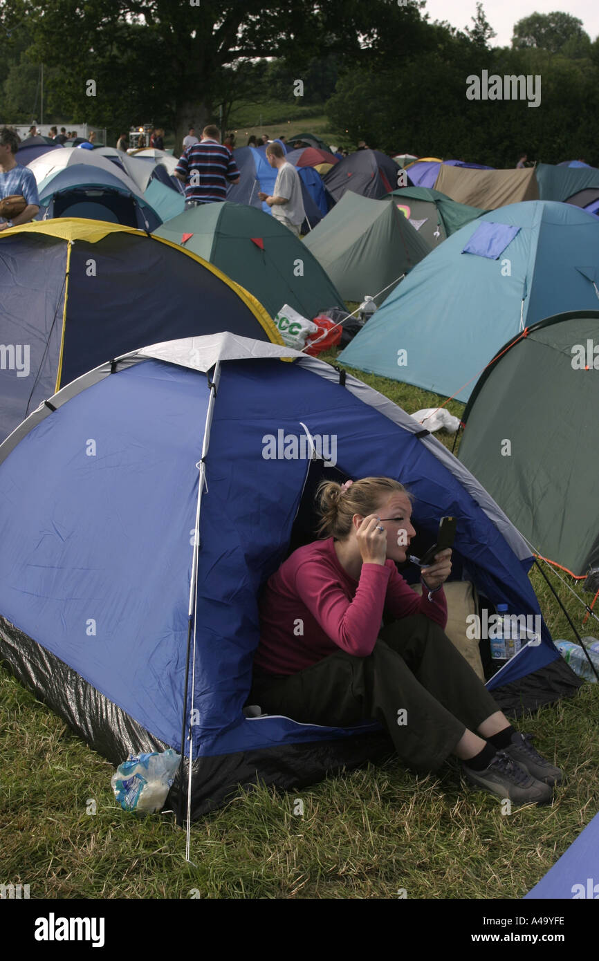 Glastonbury Festival 2003; Ein junges Mädchen setzt auf Augen-Make up von ihrem Zelt Stockfoto