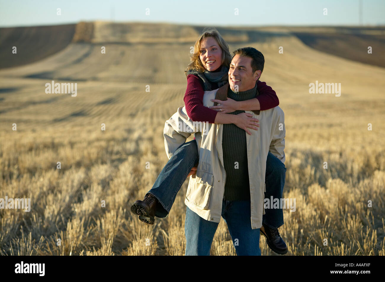 Auf lachende Frau mans wieder in Grasschnitt Felder im Herbst Colorado Stockfoto
