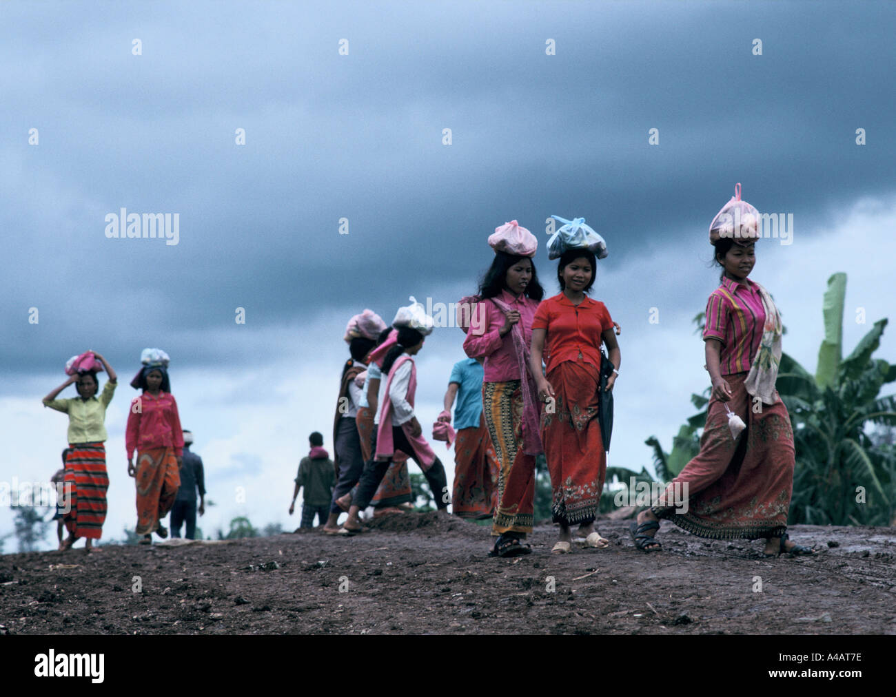 Womencarrying Gegenstände auf dem Kopf in einem Camp der Roten Khmer in Kambodscha nah an der thailändisch-kambodschanischen Grenze. Stockfoto